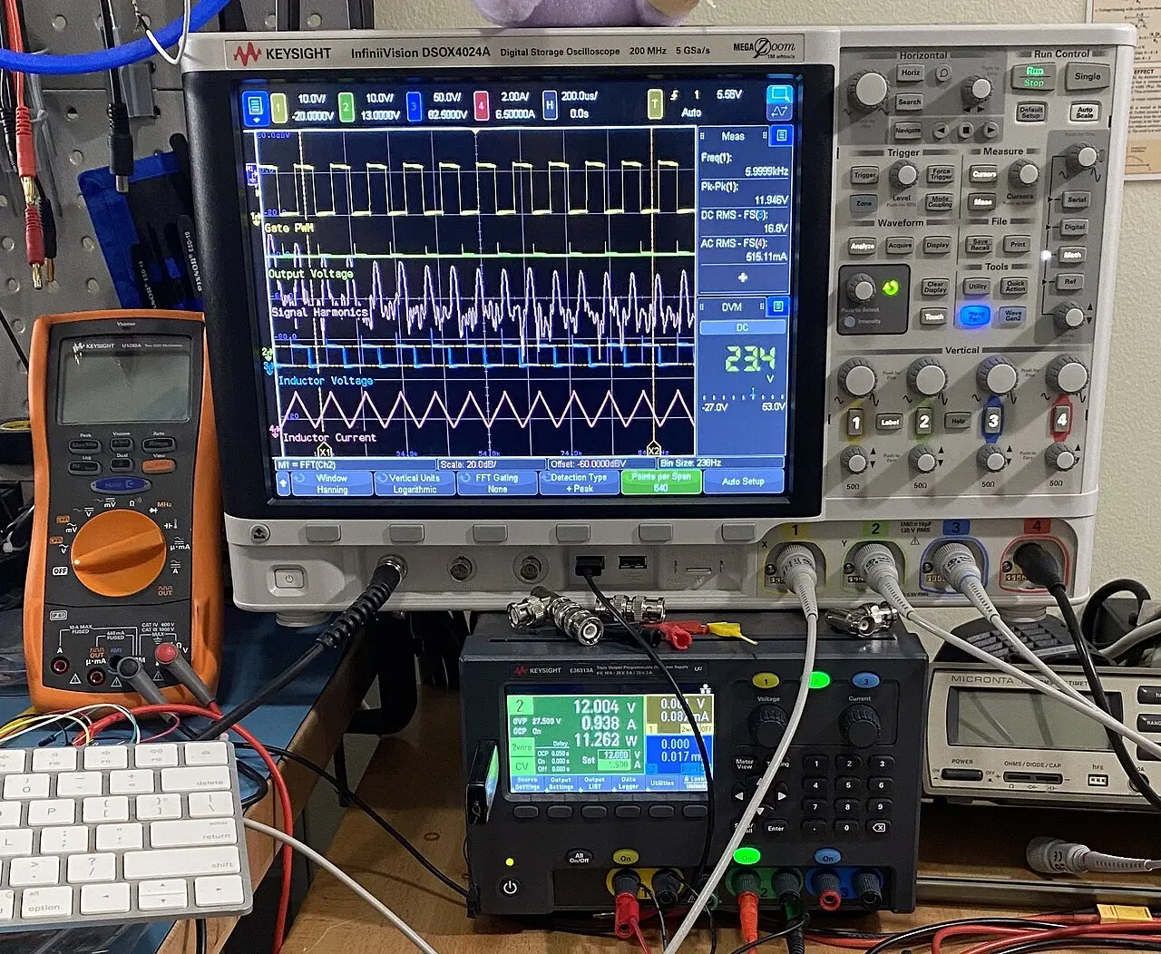 An oscilloscope and test gear on an electronics bench